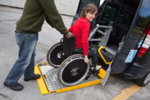 A woman in a wheelchair is getting into a van.