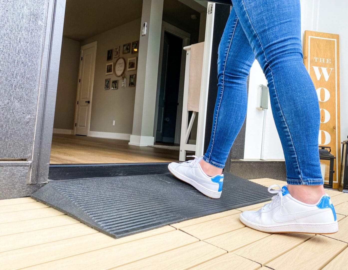 A person walking on the ground in front of a door.