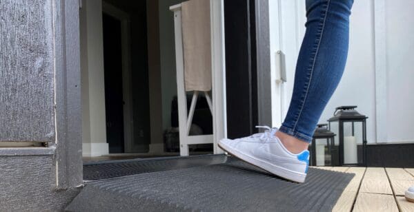 A person standing on the steps of their home.