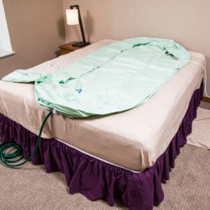 A bed with a green blanket on it