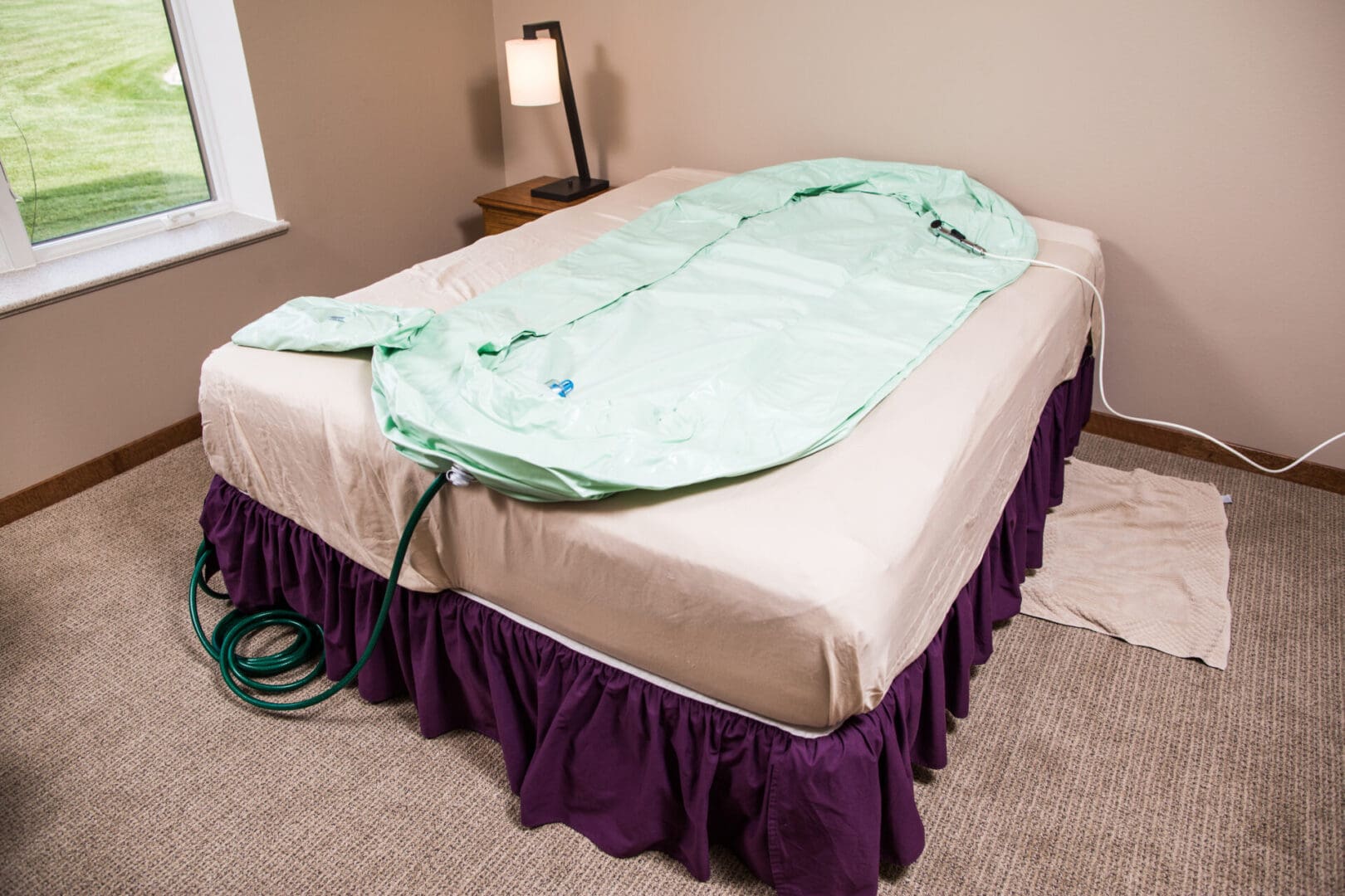 A bed with a green blanket on it