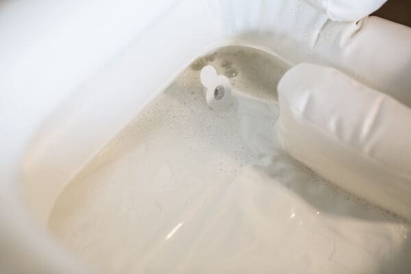 A bathroom with white walls and floor, and a toilet paper roll.