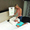 A woman is standing next to a bed with a baby in it.