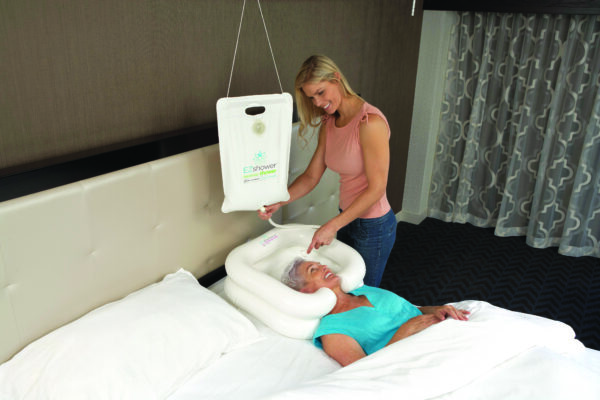 A woman is standing next to a bed with a baby in it.