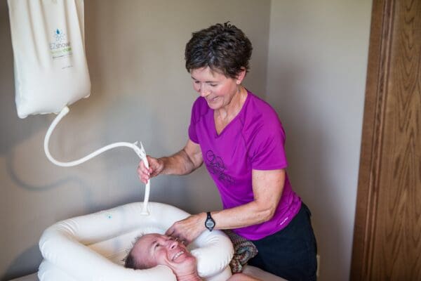 A woman is washing a baby in the tub