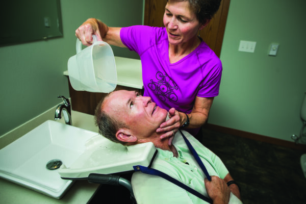 A woman is giving a man a facial