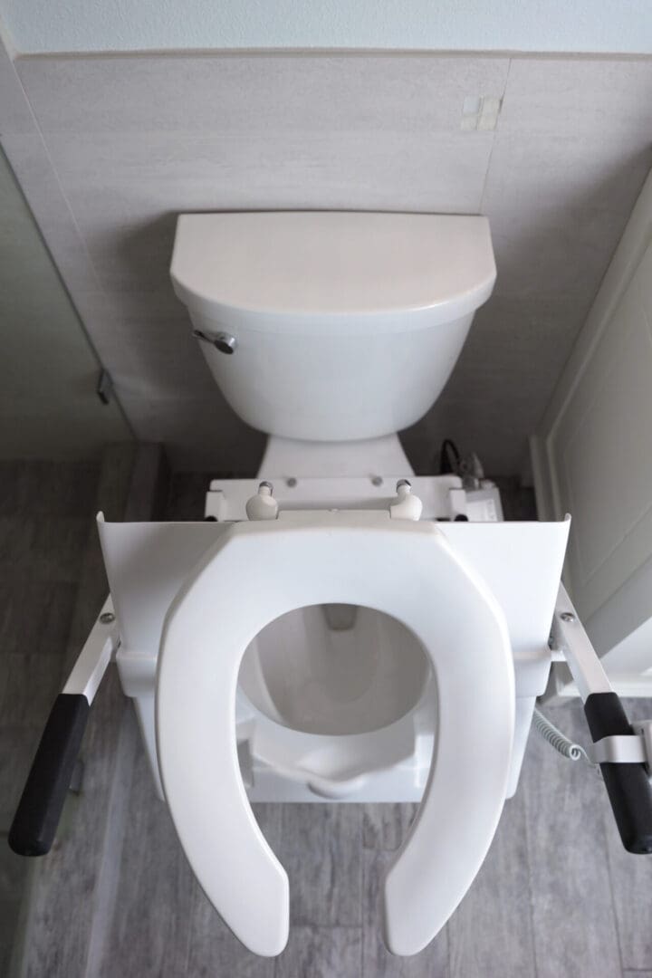 A toilet with the seat up in a bathroom.