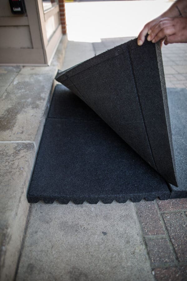 A black mat on the ground with a large wedge.