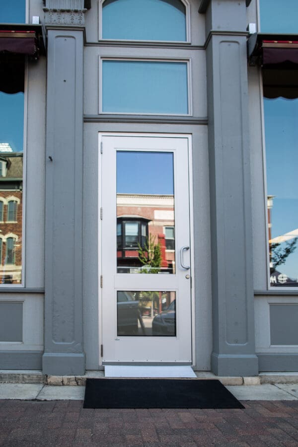 A white door with two windows on the outside of a building.