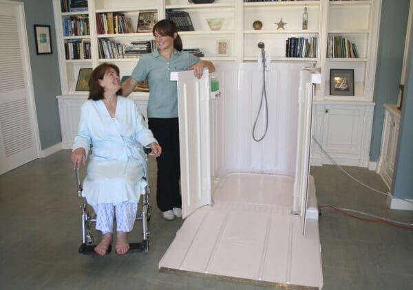 A woman standing next to another person in a wheelchair.